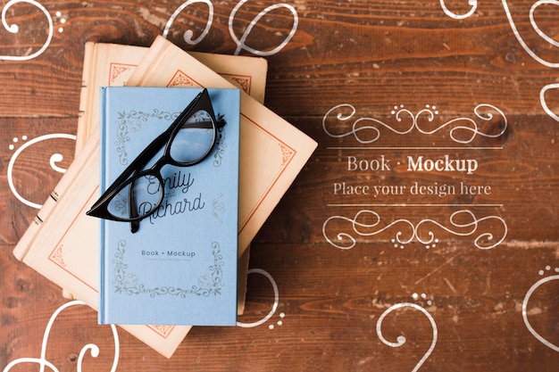 Download Postura plana de livro com óculos no topo mock-up | PSD Grátis