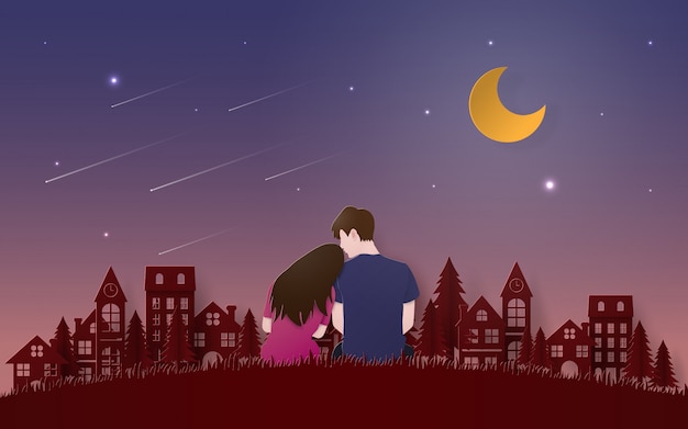 Pareja sentada en el suelo de hierba mirando meteorito Vector Premium