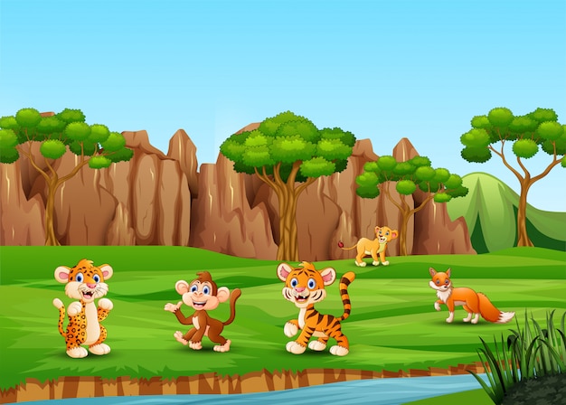 Desenhos animados de animais selvagens jogando e curtindo no campo Vetor Premium