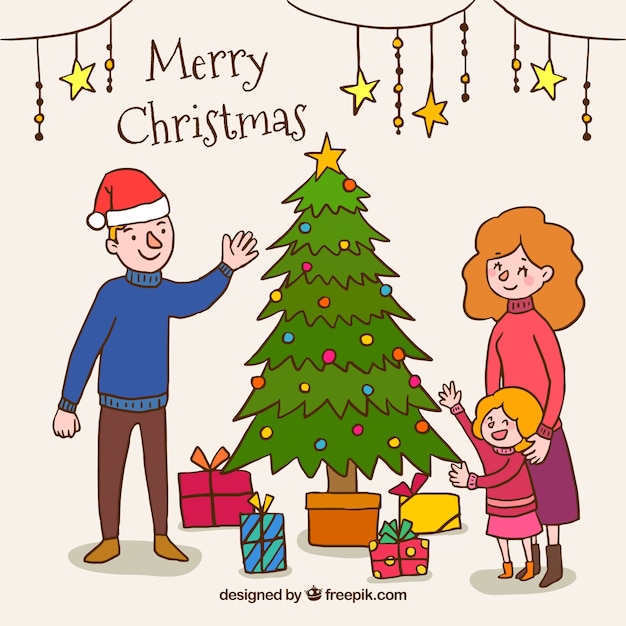 Albero Di Natale Con Foto Di Famiglia.Sfondo Disegnato A Mano Con Una Famiglia Accanto Ad Un Albero Di Natale Vettore Gratis