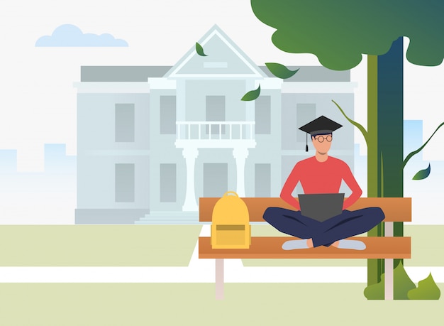Studente che studia e che utilizza computer portatile sul banco nel parco della città universitaria Vettore gratuito