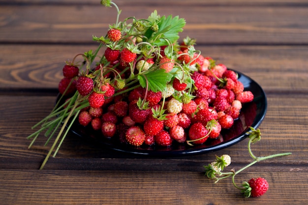 Aardbeien in een witte mok op een rustieke houten tafel. het concept van biologisch voedsel. rustieke stijl Premium Foto