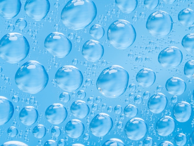Abstracte blauwe sferische bolle druppels water op glas. bubbels op het raam | Premium Foto