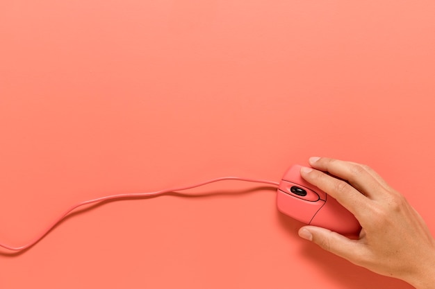Anonieme gebruiker die op een roze usb-computermuis klikt Gratis Foto