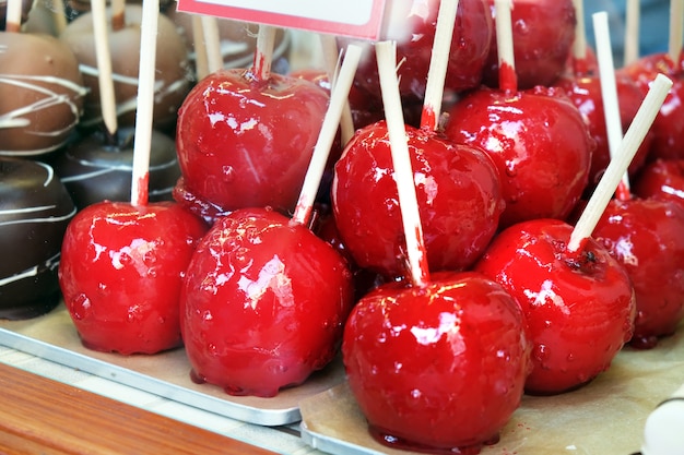 Appels bedekt met rode glazuur in een snoep. geglazuurd gekarameliseerd fruit, vakantietraktaties kinderen. | Premium Foto