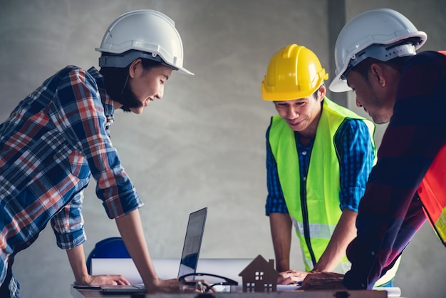 Architect en ingenieur werkt tekendocument over projectplanning en voortgang van het werkschema op de bouwplaats voor woningbouw Premium Foto