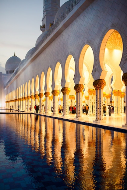 Archs of shekh zayed grote moskee weerspiegelen in het water daarvoor Gratis Foto
