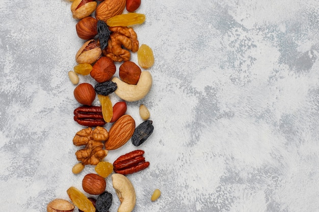 Assortiment noten in keramische platen. cashewnoten, hazelnoten, walnoten, pistache, pecannoten, pijnboompitten, pinda, rozijnen. bovenaanzicht Gratis Foto