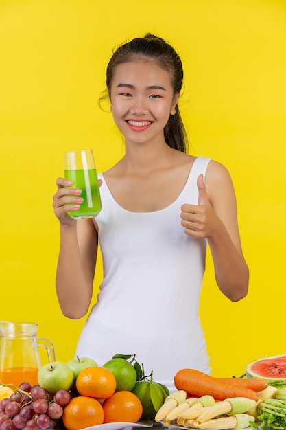 Aziatische vrouw holdingapple glas met je rechterhand, en op de tafel