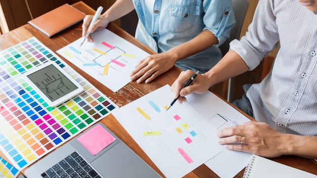 Bedrijfstechnologieconcept, creatieve teamontwerper die steekproeven kiezen met ui / ux die zich op het ontwerp van de schetslay-out op smartphonetoepassing ontwikkelen voor de mobiele grafiek van het gebruikersinterfacevoorwerp. Premium Foto