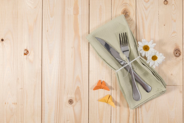 Bestek en bloemen op houten tafel Gratis Foto