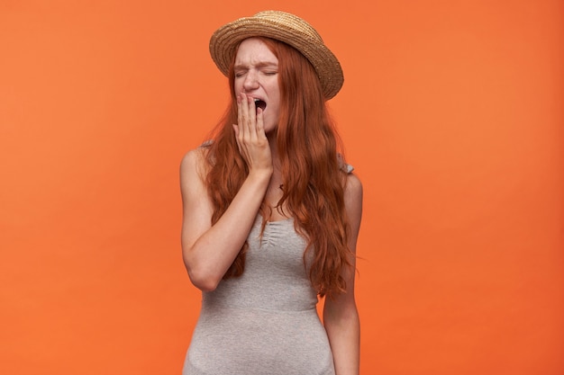 Binnen schot van vermoeide mooie roodharige jonge vrouw ...