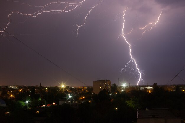 Bliksemweer over de stad in paars licht. Premium Foto