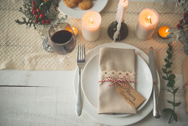 Borden, bestek, servet en glas wijn opgesteld voor kerstdiner op tafel