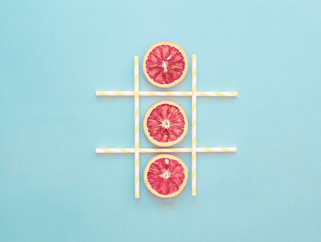 Boter-kaas-en-eieren game sinaasappelschijfje, gezond zomerconcept, lichtblauw, minimalisme Premium Foto