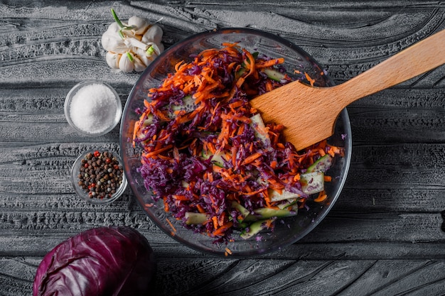 Bovenaanzicht plantaardige salade in kom met met kruiden op donkere