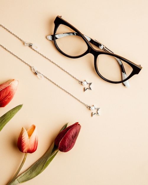 Brillen voor vrouwen tulpen en accessoires op tafel Gratis Foto