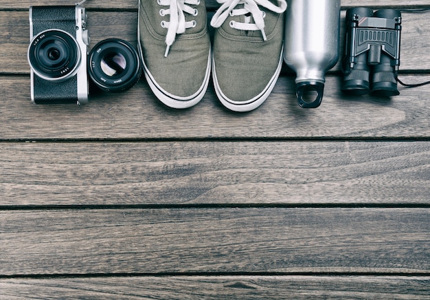 Camera, lens, verrekijker, canvas schoenen, sportfles op de retro