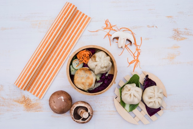 Chinese gestoomde dimsum in de traditionele keuken van bamboecontainers op witte houten lijst Gratis Foto