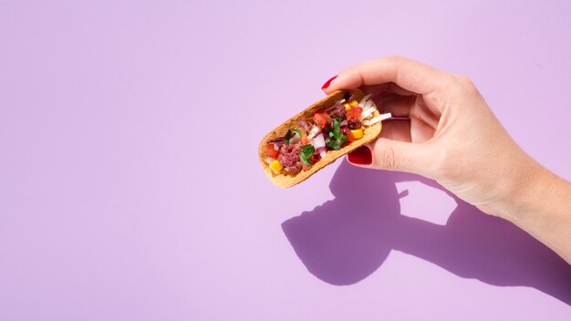 Close-upvrouw met taco, exemplaar-ruimte en purpere achtergrond Gratis Foto