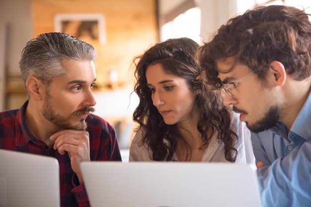 Commercieel team dat ideeën genereert voor projecten, met behulp van laptops Gratis Foto