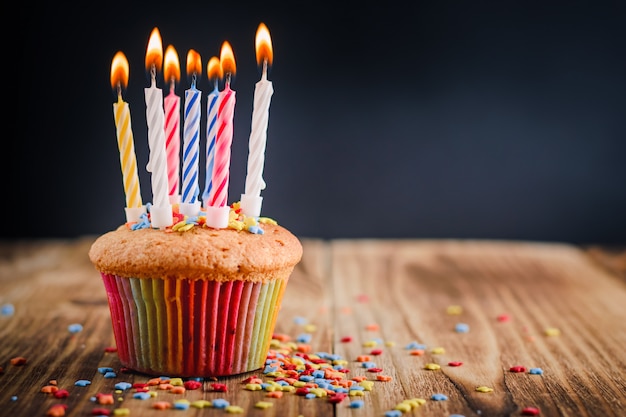 Cupcake met feestelijke aangestoken kaarsen Premium Foto