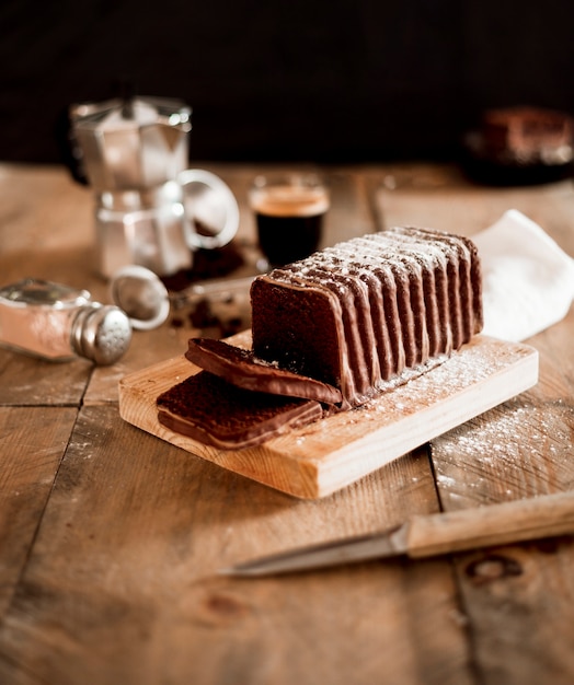 De cakeplakken van de chocolade op houten hakbord over de lijst