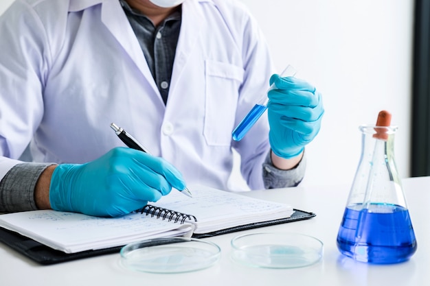 De chemicus analyseert steekproef in laboratorium met apparatuur en wetenschapsexperimenten Premium Foto