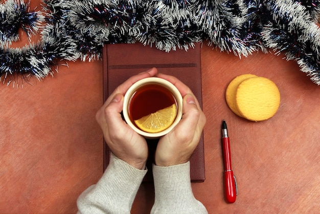 De Handen Met Een Kopje Thee Op De Tafel Op Kantoor Voor De Kerst