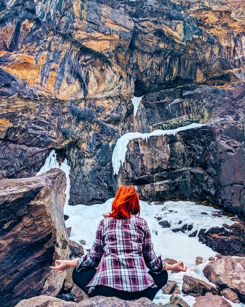 De jonge yogavrouw zit meditatie op berg piekrots. Premium Foto