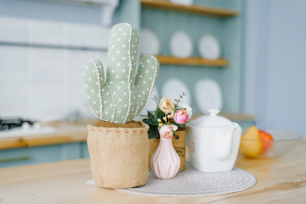 Decoratieve zachte cactus in een pot. roze vaas met bloemen en een witte ketel in het decor van de keuken in de scandinavische stijl, minimalistisch beknopt Premium Foto