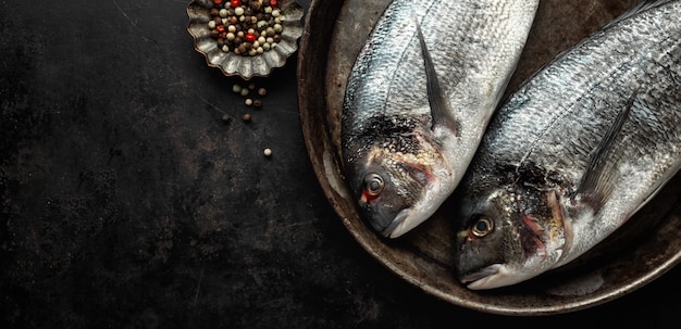 Doradovissen met ingrediënten op dark Gratis Foto