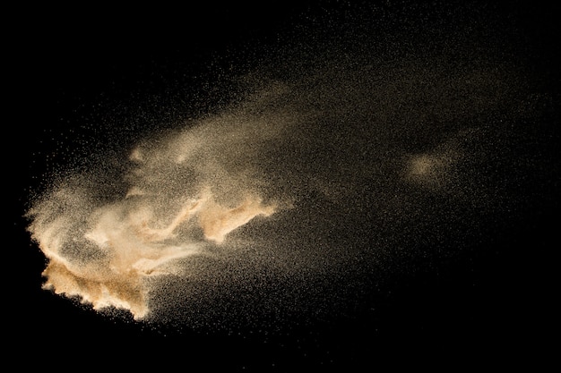 Droge rivier zand explosie geïsoleerd op zwarte achtergrond. abstracte zandwolk. bruine gekleurde zandplons tegen donkere achtergrond. Premium Foto