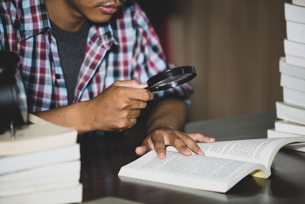 Educatief thema: close-up student kijkt door een vergrootglas om te boeken Gratis Foto