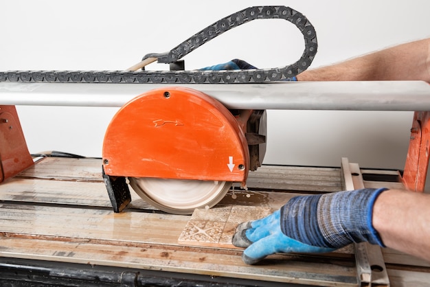 Een arbeider snijdt een keramische tegel op een natte | Premium Foto