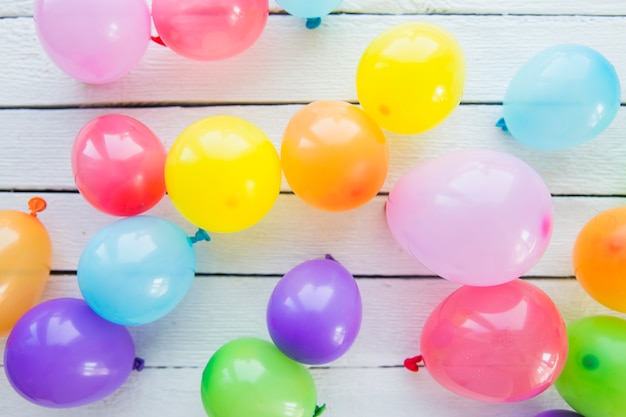 Een bovenaanzicht van opblaasbare ballonnen op houten plank Gratis Foto
