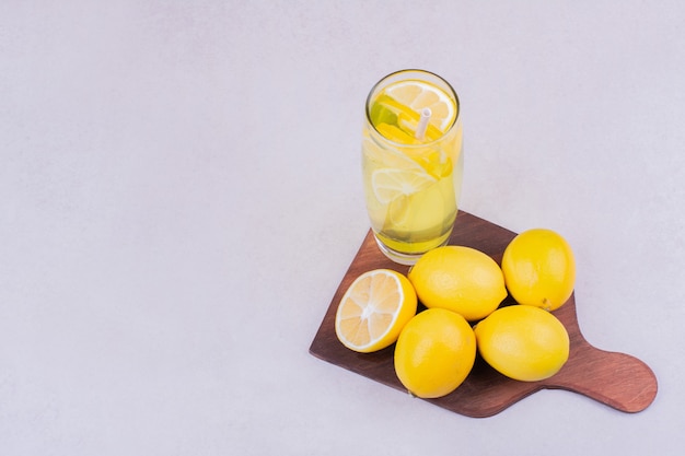 Een Glas Limonade Met Citroenen Op Een Houten Schotel Gratis Foto