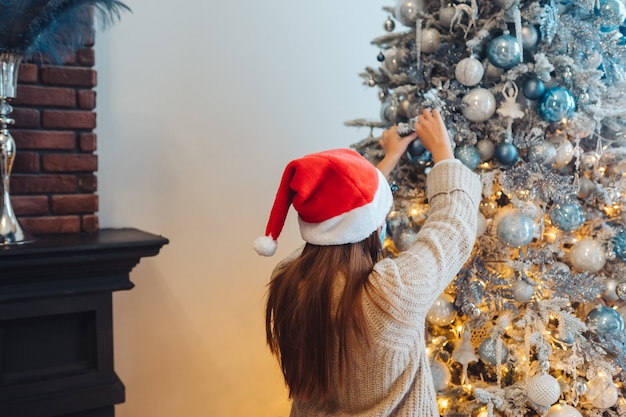 Een Jonge Vrouw Versiert De Kerstboom Gratis Foto