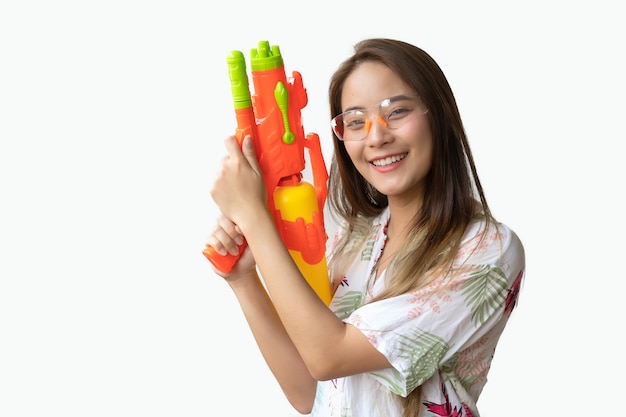 Een mooie thaise vrouw die vers en gelukkig glimlacht, in haar hand die een waterkanon in het thaise songkran-festival op een witte achtergrond houdt. Premium Foto
