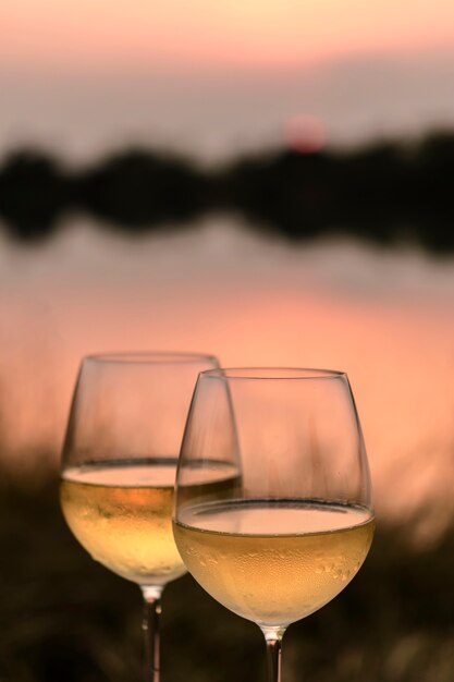 Een Romantisch Diner In De Zomer Op Een Strand Bij Zonsondergang Met Twee Glazen Witte Wijn Premium Foto