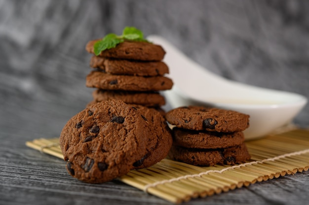 Een stapel koekjes en een lepel melk op een doek op een houten tafel Gratis Foto