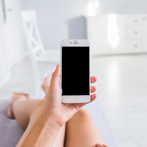 Een vrouw die mobiele telefoon met het lege scherm toont Gratis Foto