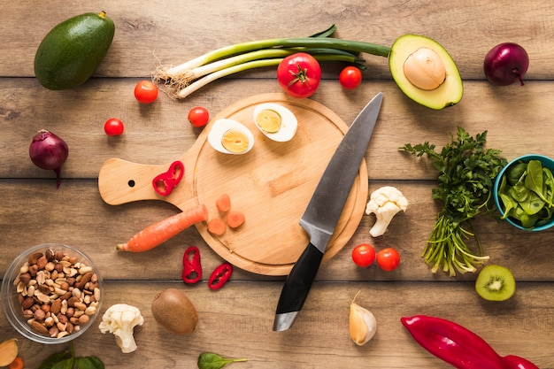 Ei; groenten en verse ingrediënten met mes op houten tafel Gratis Foto