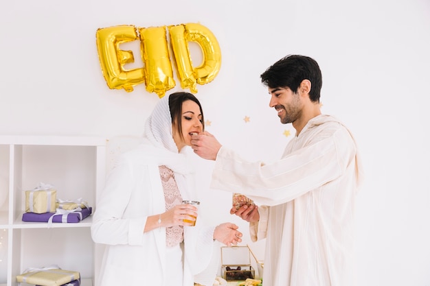 Eid al-fitr concept met paar die koekjes eten | Gratis Foto