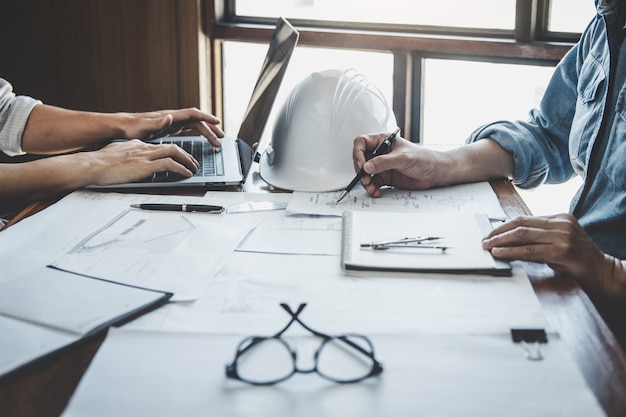 Engineer teamwork meeting, tekenen aan blauwdrukvergadering voor project werken met partner op modelbouw en engineeringtools in werklocatie, constructie en structuurconcept Premium Foto
