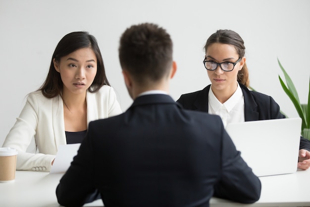 Ernstige niet-overtuigd diverse hr-managers interviewen mannelijke sollicitant Gratis Foto