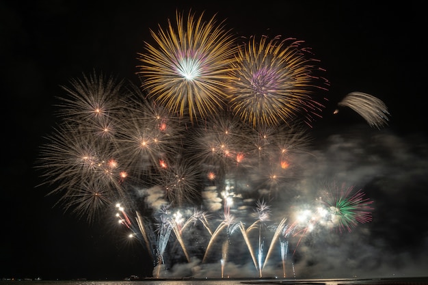 Fantastisch veelkleurig vuurwerk exploderend voor viering van de grote boot over het overzees Premium Foto