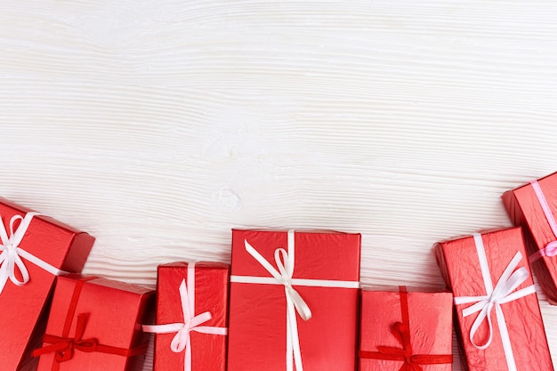 Frame van rode geschenken op wit hout Premium Foto