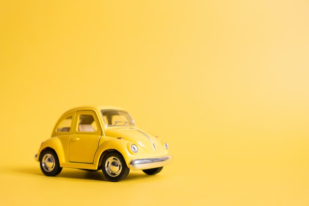 Geel. retro speelgoedauto op geel. zomer reizen concept. taxi Premium Foto