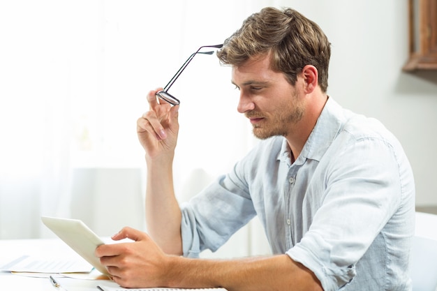 Gefrustreerde mens die digitale tablet in bureau gebruiken Premium Foto